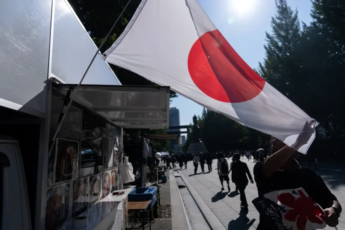 Un vendedor muestra una bandera nacional japonesa afuera de su camión de comida en el Santuario Yasukuni